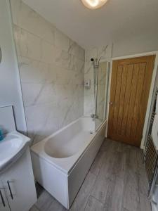 a white bathroom with a tub and a sink at Charming 2 BedRoom Tredegar Gem. Sleeps 4 in Tredegar