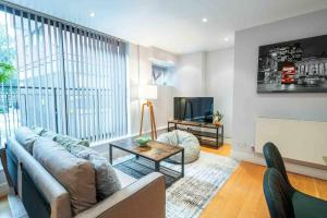 ein Wohnzimmer mit einem Sofa und einem TV in der Unterkunft Stunning 3-Bed House in central London in London