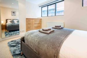 ein Schlafzimmer mit einem Bett mit zwei Handtüchern darauf in der Unterkunft Stunning 3-Bed House in central London in London