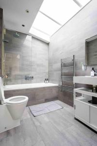 La salle de bains est pourvue d'une baignoire, de toilettes et d'un lavabo. dans l'établissement Stunning 3-Bed House in central London, à Londres
