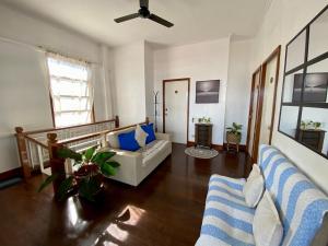 a living room with two couches and a ceiling fan at MyGuide Travellers Inn in Coron