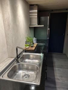 eine Küche mit einer Edelstahlspüle in der Küche in der Unterkunft Gamla stallet in Helsingborg