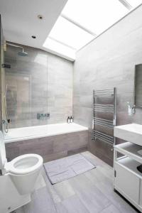 Immaculate 1-Bed House in London في لندن: حمام مع حوض ومرحاض ومغسلة