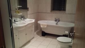 y baño con bañera, lavabo y aseo. en CELLAR COVE, en Perranporth
