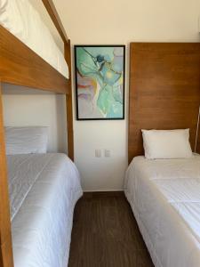 a bedroom with two beds and a painting on the wall at Villas La Mar in Monterrico