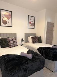 a room with two beds withskirts at Sleek & Stylish Apartment by DH ApartHotels in Peterborough