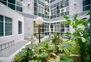 an office building with a courtyard with plants at Sleek & Stylish Apartment by DH ApartHotels in Peterborough