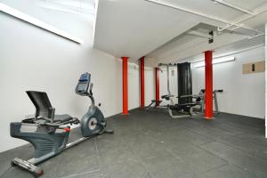 una palestra con 2 tapis roulant e macchinari per il cardio-fitness di Sleek & Stylish Apartment by DH ApartHotels a Peterborough