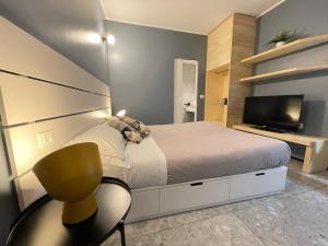 a bedroom with a bed and a television and a chair at Torino48 Guesthouse in Milan