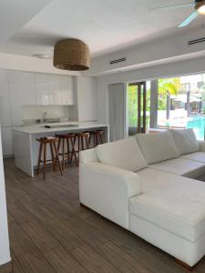 a living room with a white couch and a kitchen at Villas La Mar in Monterrico