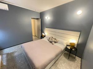 a bedroom with a white bed and a blue wall at Torino48 Guesthouse in Milan