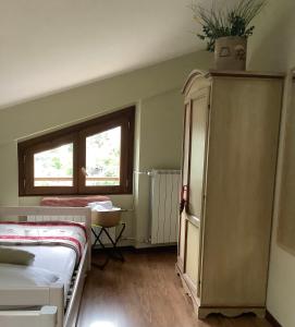 um quarto com uma cama, um armário e uma janela em La cerbiatta em Castel di Sangro