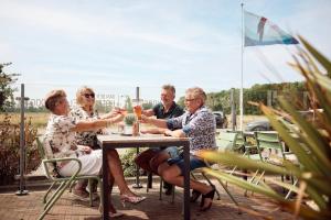 eine Gruppe von Menschen, die an einem Tisch sitzen in der Unterkunft Van der Valk Texel - De Koog in De Koog