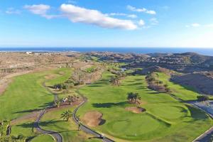 una vista aérea de un campo de golf con el océano en el fondo en Salobre Vista Golf 27, en Maspalomas