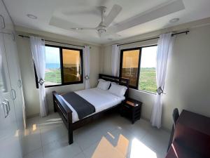 - une chambre avec un lit et 2 grandes fenêtres dans l'établissement Remarkable 3-Bed Apartment in Zanzibar, à Fumba