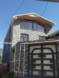 a house with a garage door in front of it at Lahij Ismayilov Hotel in İsmayıllı