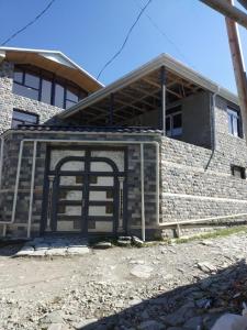 un edificio de ladrillo con una puerta delante de él en İsmayilov's-Lahij hotel, en İsmayıllı