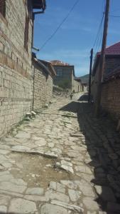 an alley with a stone road next to a building at İsmayilov's-Lahij hotel in İsmayıllı