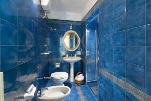 ein blau gefliestes Bad mit WC und Waschbecken in der Unterkunft Estate4home- La casa del Maresciallo in Positano