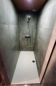 a bathroom with a shower with a white floor at Le Havre du Circuit / Triplex avec Sauna in Malmedy