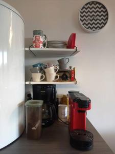 encimera de cocina con cafetera y estanterías con tazas en Le Havre du Circuit / Triplex avec Sauna en Malmedy