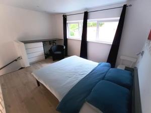 1 dormitorio con cama, escritorio y ventana en Le Havre du Circuit / Triplex avec Sauna en Malmedy
