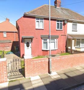 una casa de ladrillo rojo con una valla delante de ella en Stratford House Hartlepool Horizon Stays, en Hartlepool
