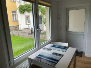 um quarto com uma mesa branca e uma grande janela em Ferienwohnung Pirna mit Elbblick em Pirna