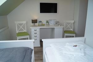 a bedroom with a bed and a desk and a tv at REGIOHOTEL Aparthotel Wernigerode in Wernigerode