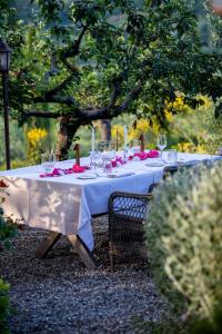 a table with a white table cloth and wine glasses at Lupaia in Montepulciano