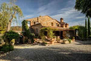 a large brick house with plants in a yard at Lupaia in Montepulciano