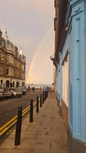 a rainbow in the sky over a street with buildings at Portobello Charming Seaside 3-BR Holiday Apartment in Edinburgh