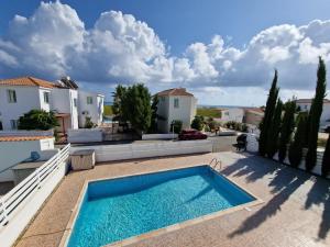 una piscina en medio de un patio con casas en Mandria, 3 bed with pool en Mandria