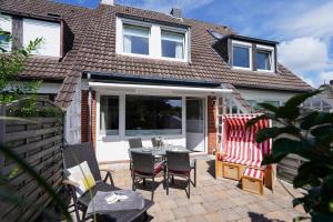 eine Terrasse mit einem Tisch und Stühlen auf einer Terrasse in der Unterkunft Süderliebe in Westerland