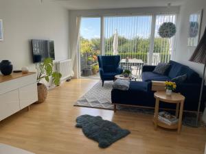uma sala de estar com um sofá azul e uma televisão em Velindrettet rækkehus med fantastisk udsigt em Næstved
