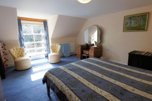 een slaapkamer met een bed, een spiegel en een raam bij Tolsta in Killin