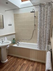 ein Badezimmer mit einer Badewanne und einem Waschbecken in der Unterkunft The Haven in Saint Fillans
