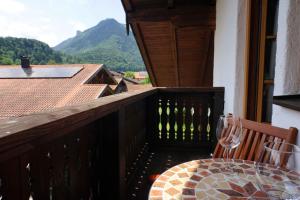 - un balcon en bois avec une table et un verre de vin dans l'établissement eleven Marquartstein, à Marquartstein