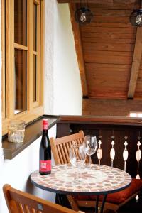 einen Tisch mit einer Flasche Wein und zwei Gläsern in der Unterkunft eleven Marquartstein in Marquartstein