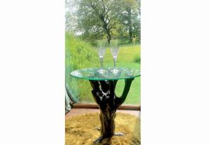 a glass table with two wine glasses on top at Romantic Rural Break In Countryside Castle Grounds Private Retreat Wizards Rest in Bishops Tawton +19 photos