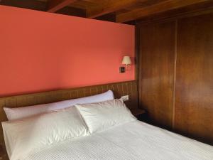 MazaricosにあるA Casiña do Campoの赤い壁のベッドルーム1室(白いベッド1台付)