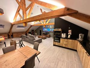 a large living room with wooden ceilings and a table at loft 100m2 confort+. Chez Cédric et Jeza in Le Thillot