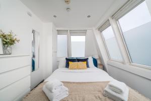 a small bedroom with a bed and two windows at Stunning 2 Bedroom Brighton Apartment - Sleeps 6 in Brighton & Hove