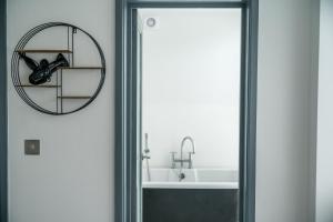 a bathroom door with a bike hanging on the wall at Stunning 2 Bedroom Brighton Apartment - Sleeps 6 in Brighton & Hove