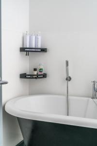 a bath tub in a bathroom with two shelves at Stunning 2 Bedroom Brighton Apartment - Sleeps 6 in Brighton & Hove