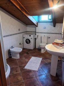 ein Badezimmer mit einem Waschbecken und einer Waschmaschine in der Unterkunft Il Vecchio Lentisco in Alghero