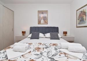 a bedroom with a large bed with a floral bedspread at Apartments Barba in Tučepi
