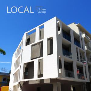 a white apartment building against a blue sky at Local Urban Living in Volos