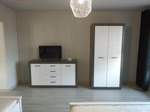 Zimmer mit einer weißen Kommode, einem TV und einem Spiegel in der Unterkunft Apartament u Irenki in Harklowa