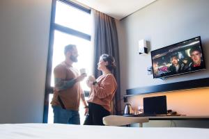 a man and a woman standing in a hotel room at Naalt Hotel Joinville in Joinville